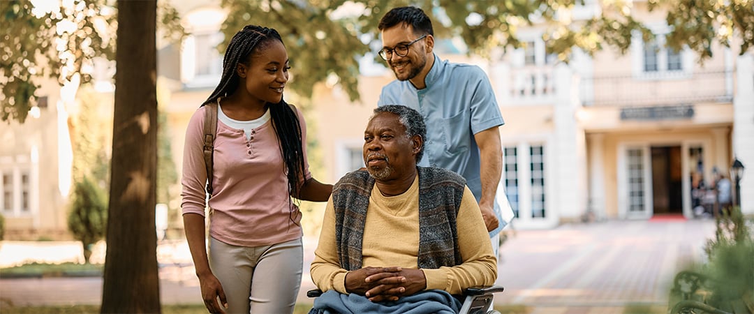 A senior man visiting with his family outside